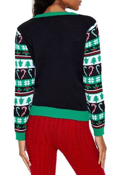 a woman wearing a black sweater with green and red christmas jumpers on it's sleeves