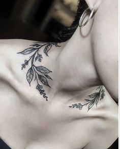 a woman's chest with leaves and flowers tattooed on her left side ribcage