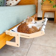 an orange and white cat laying on top of a bed in a hammock