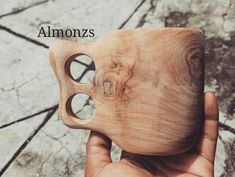 a hand holding a wooden object with the words almonzs on it's side