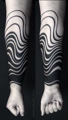 the arm is covered in black and white lines, with one hand on top of the other