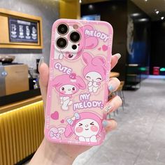 a person holding up a pink phone case with cute cartoon characters on the front and back