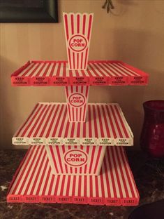 three red and white striped boxes stacked on top of each other in front of a wall