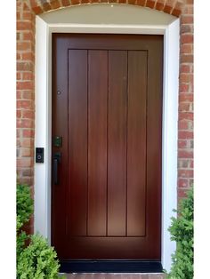 a wooden door with brick wall and white trim