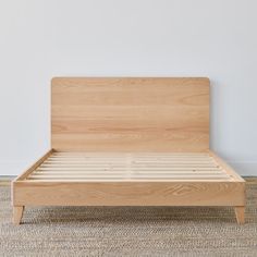 a wooden bed frame with no headboard and foot board on carpeted flooring