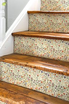 the stairs are decorated with floral wallpaper and wooden handrails, along with a white stair case