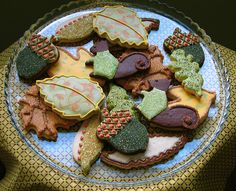 decorated cookies on a plate with leaves and acorns