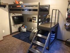 a loft bed with a ladder next to it and a tv on the wall behind it