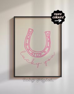 a drawing of a pink horseshoe hangs on the wall