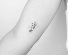 a small seahorse tattoo on the arm