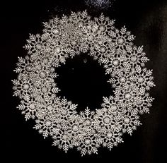 a white snowflake on a black background with space for the letter o in the center