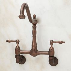 an old fashioned faucet with two handles on the wall