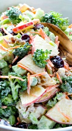 a salad with broccoli, apples, cranberries and cheese