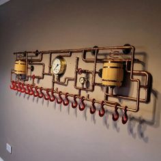 there is a wall with some pipes on it and a clock mounted to the wall