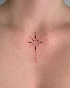 a close up of a person's chest with a cross tattoo on the chest