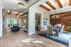 a large open concept living and dining room with wood flooring, white walls and ceiling