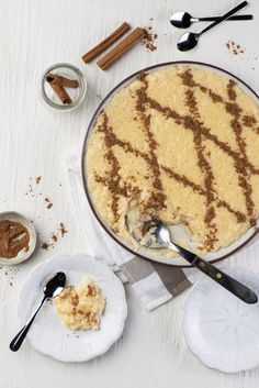 a dessert dish with chocolate and cinnamon on top, next to two small bowls filled with powdered sugar