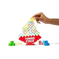 a hand is holding a tower stack game