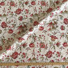 a white fabric with red flowers on it and a measuring tape in front of it