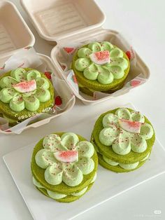 four green cupcakes with white frosting and sprinkles on them