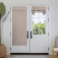 a white door with two windows and a chair in front of the doors is shown