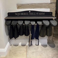 there is a sign that says squirrel hill farm with many pairs of slippers hanging from it