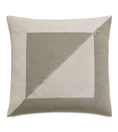 a grey and white pillow with a gold triangle on the front, along with a zippered closure