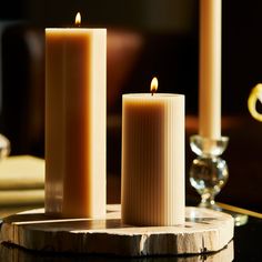 two lit candles sitting on top of a table