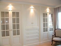 a living room with white walls and wooden flooring, lighted by recessed lighting