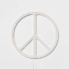 a white peace sign is hanging on the wall