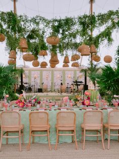 a table set up with pink flowers and greenery for a wedding or event reception