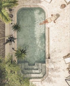 an aerial view of a swimming pool surrounded by palm trees