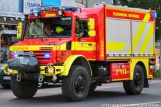 a red and yellow fire truck driving down the street