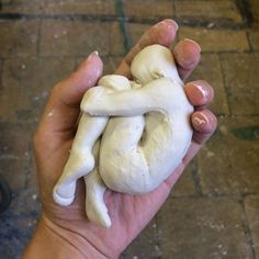 a person holding a fake human heart in their left hand on the ground next to a brick floor