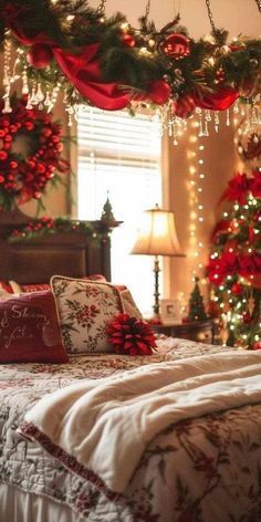 a bedroom decorated for christmas with red and green decorations on the bed, lights strung from above