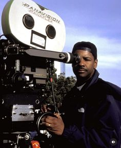 a man standing next to a movie camera