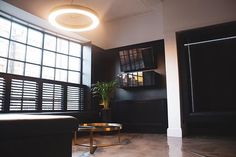 a living room filled with furniture and large windows next to a window covered in blinds