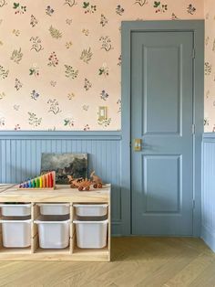 a child's playroom with storage bins and wallpaper on the walls