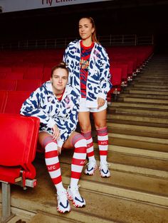 two people sitting on the bleachers at a stadium wearing matching outfits and socks