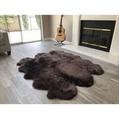 a living room filled with furniture and a fire place covered in sheepskin rugs