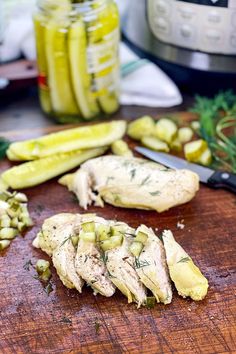 sliced chicken and pickles on a cutting board next to an instant pressure cooker