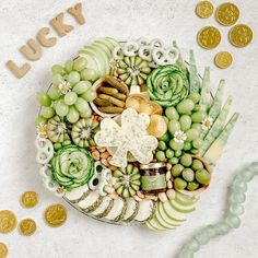 a platter filled with lots of different types of food next to some gold coins