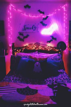 a bed with purple lights and bats on the headboard, in a bedroom decorated for halloween