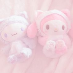 two stuffed animals laying on top of a white blanket