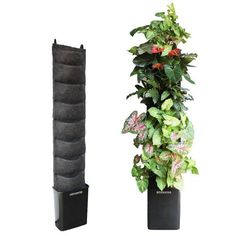 a tall planter with plants in it next to a large black potted plant