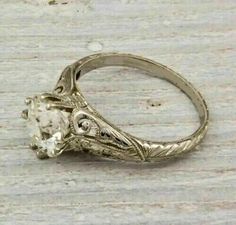 an antique style engagement ring with a white diamond