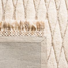 a close up of a rug on the floor with some fringes hanging from it