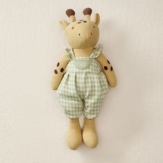 a giraffe stuffed animal hanging on the wall