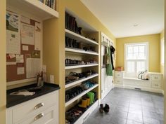 a walk in closet filled with lots of shoes and other items next to a window