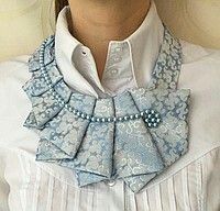 a close up of a person wearing a white shirt with blue flowers on the collar